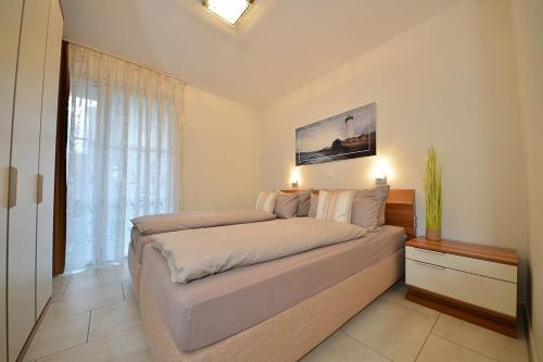 a bedroom with a bed and a large window at Villa Verdi - Ferienwohnung 2 in Wangerooge