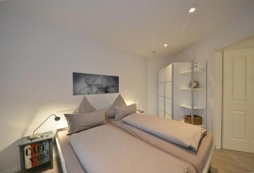 um quarto com uma grande cama branca num quarto em Ferienwohnung Dünenperle em Wangerooge