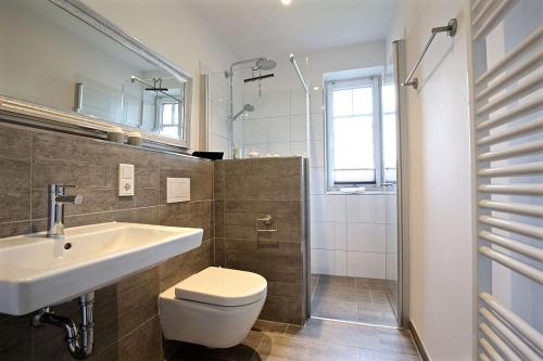 uma casa de banho com um WC, um lavatório e um chuveiro em Ferienwohnung Dünenperle em Wangerooge