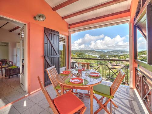 a dining room with a table and chairs on a balcony at Habitation Bellevue in Sainte-Anne