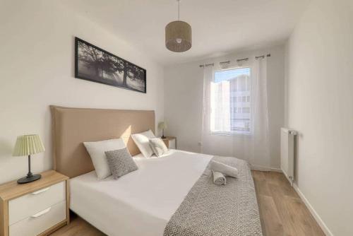 a bedroom with a large white bed and a window at Le duplex Disneyland Bmyguest in Montévrain