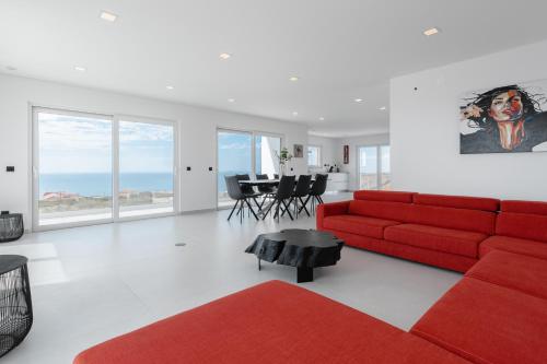 uma sala de estar com um sofá vermelho e uma mesa em Villa Carpe Diem em Lourinhã