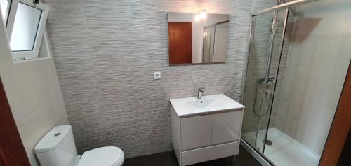 een badkamer met een toilet, een wastafel en een douche bij Casa Rosa in Monte Gordo