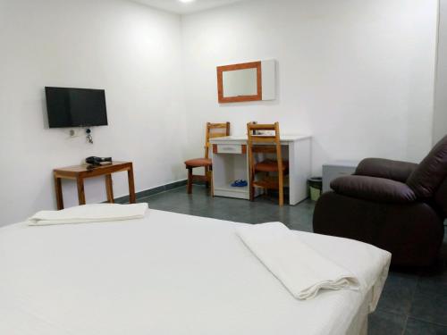 a room with a bed and a couch and a television at RESIDENCIAL AFRICA,LDA-NAMPULA in Nampula