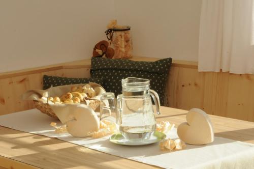 a table with a pitcher of water and a basket of mushrooms at Gerlhof in Obernussdorf