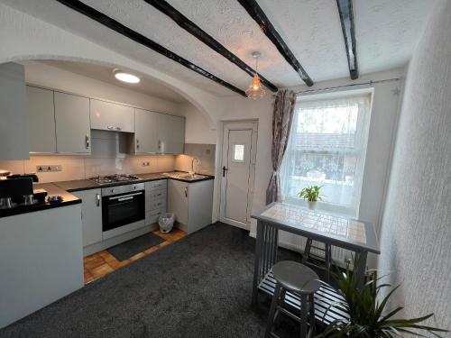 a kitchen with white cabinets and a table and a window at The Pleasure 6&8 in Morecambe