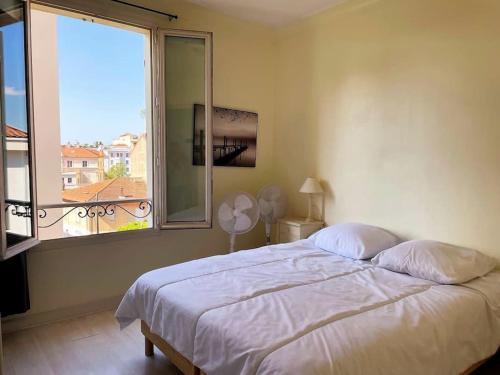 une chambre avec un lit et une grande fenêtre dans l'établissement C043-Agréable 3 Pièces proche Croisette et plages, à Cannes
