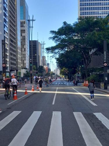 a city street with people walking and bicycling at Hostel Trilhas e Rotas - a 150m da Avenida Paulista in Sao Paulo