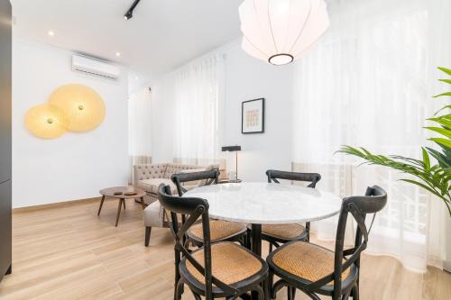 a dining room with a white table and chairs at iloftmalaga Santa María in Málaga