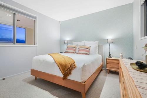 a white bedroom with a bed and a window at Ponsonby Delight with Wi-fi and Free Parking in Auckland