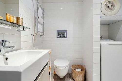 a white bathroom with a sink and a toilet at Ponsonby Delight with Wi-fi and Free Parking in Auckland