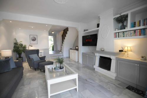 uma sala de estar com um sofá e uma lareira em Casa Jardines del Sol J2 em Marbella