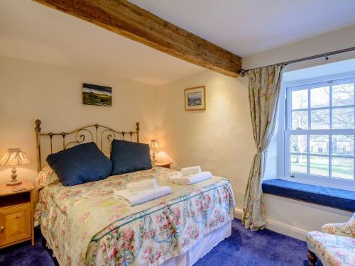 a bedroom with a large bed and a window at Middle Cottage in West Burton