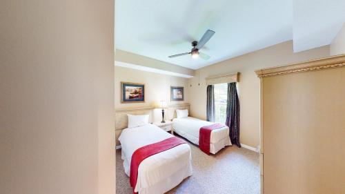 1 dormitorio con 2 camas y ventilador de techo en Pura Vida, en Orlando