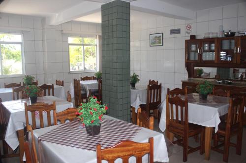 a restaurant with tables and chairs with flowers on them at Hotel Rey in Camaçari