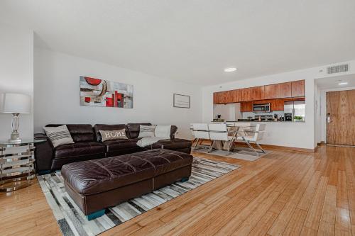 a living room with a brown couch and a kitchen at Miami condo with city & ocean views! Sleep up to 6! in Miami