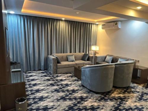 a living room with a couch and a room with a rug at فندق امان أبها - المحالة in Abha