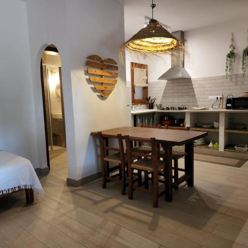 a kitchen with a wooden table and some chairs at Appartamentos Michel Dos in Sant Ferran de Ses Roques