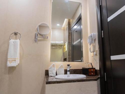 a bathroom with a sink and a mirror at فندق امان أبها - المحالة in Abha