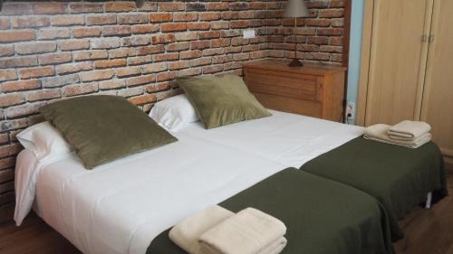two beds in a room with a brick wall at VILLA BELLA ESTANÇA in Castelldefels
