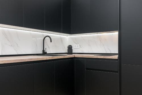 a kitchen with black cabinets and a sink at iloftmalaga Santa María in Málaga