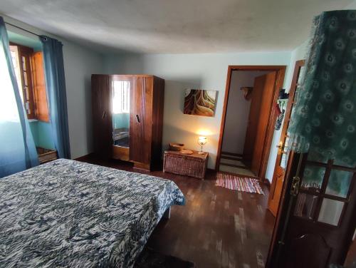 een slaapkamer met een bed en een deur naar een gang bij Het Boetje in Lagoa