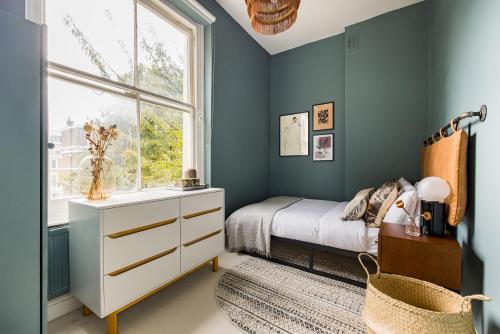 1 dormitorio con cama y ventana en The Kensington And Chelsea Classic - Glamorous 2BDR Flat en Londres