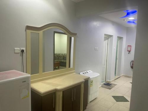 a bathroom with a large mirror on the wall at شقق ليالي الشرق للوحدات 2 in Al Mubarraz