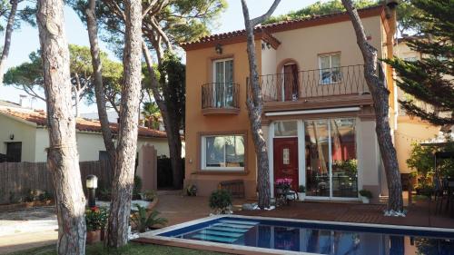 una casa con piscina frente a ella en VILLA BELLA ESTANÇA, en Castelldefels