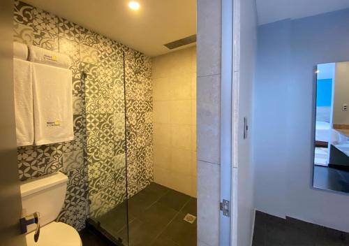 a bathroom with a toilet and a glass shower at Hotel Estrella de Oriente in Mexico City
