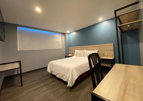 a small room with a bed and a table at Hotel Estrella de Oriente in Mexico City