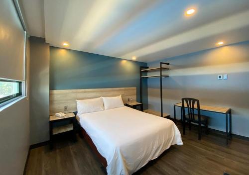a bedroom with a bed and a table and a chair at Hotel Estrella de Oriente in Mexico City