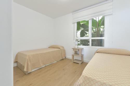 sypialnia z dwoma łóżkami i oknem w obiekcie Apartamento de lujo con jardin privado w mieście Torrox Costa
