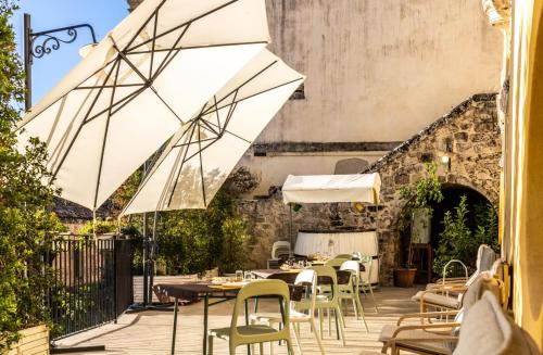 a patio with tables and chairs and an umbrella at Bed and Breakfast Terra del Sole Ibla in Ragusa