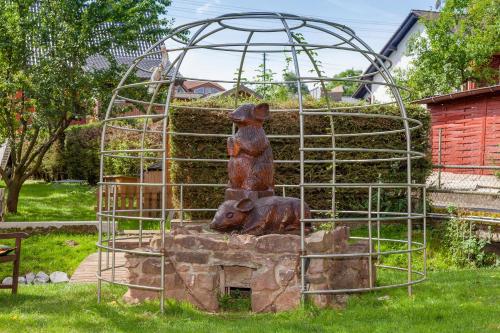 a statue of a bear sitting in front of a playground at Hotel Am Eifelsteig in Neroth