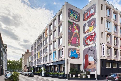 a building with lots of pictures on the side of it at Hôtel Chromatics & Restaurant Hill Club by HappyCulture in Lyon