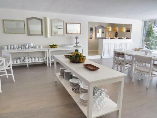 una cocina blanca con una mesa con platos. en Atlántico Boutique Hotel, en Punta del Este