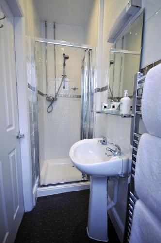 a white bathroom with a sink and a shower at St John's Lodge incl off-site leisure club in Windermere