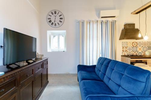 a living room with a blue couch and a clock at Latieri's Loft in Syracuse