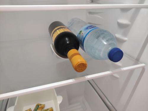 dos botellas de vino sentadas en un estante en un refrigerador en La Casita del Sendero, en La Guancha