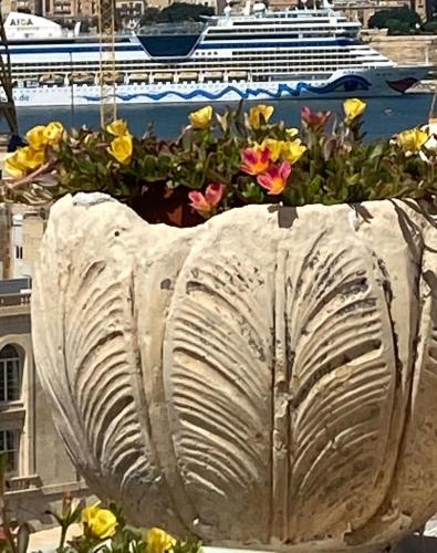 a flower pot with a cruise ship in the background at Casa Maria Tereza in Cospicua