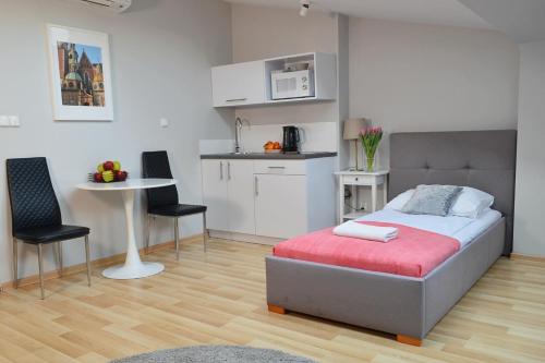 um quarto com uma cama e uma pequena cozinha em 21 Floriańska Street Apartments em Cracóvia