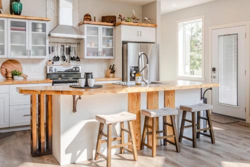 a kitchen with a wooden counter and stools at The Qanuk Fernie - Ski In Ski Out in Fernie