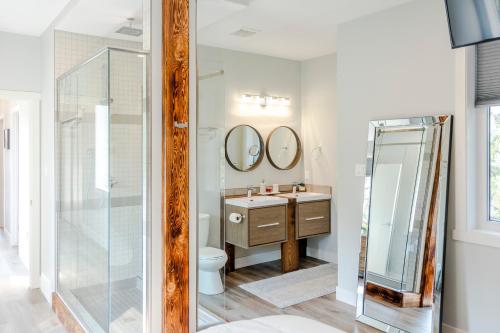 a bathroom with a toilet and a sink and mirrors at The Qanuk Fernie - Ski In Ski Out in Fernie