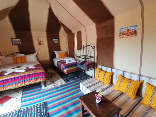 Zimmer mit einem Bett, einem Sofa und einem Tisch in der Unterkunft Riad Dades Birds in Boumalne