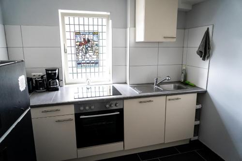 a small kitchen with a sink and a window at Ferienwohnung Rhönerluft in Poppenhausen