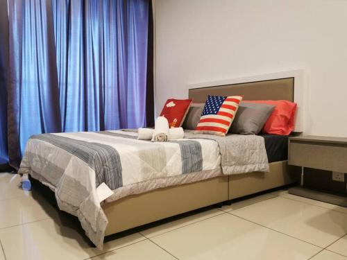 a bed with patriotic pillows on it in a room at G Studio Swimming Pool View@EVO BANGI NETFLIX+WIFI in Kampong Sungai Ramal Dalam
