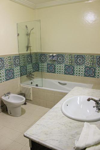 a bathroom with a tub and a toilet and a sink at Majorel Pearl Hotel-Riad-Restaurant Piscine&Spa in Marrakech