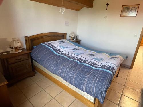 un letto con piumone blu in una camera da letto di Chambres d'hôtes a Les Genevez