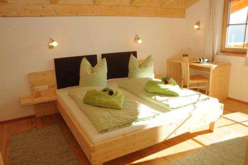 ein Schlafzimmer mit einem Holzbett mit zwei Äpfeln darauf in der Unterkunft Gerlhof in Obernussdorf
